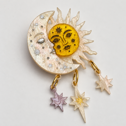 Broche Eclipse de sol y luna con tres estrellas colgantes, vista frontal.