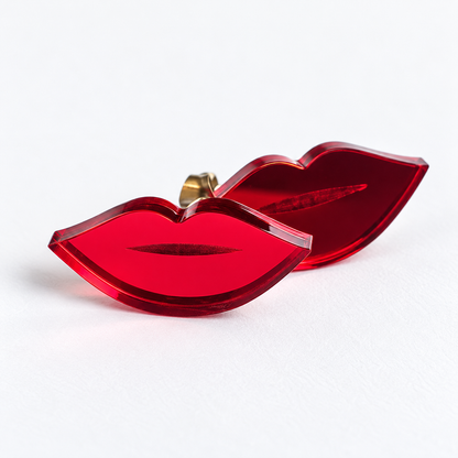 Par de pendientes Mini Labios en metacrilato rojo espejo, sobre fondo blanco limpio y en formato cuadrado.