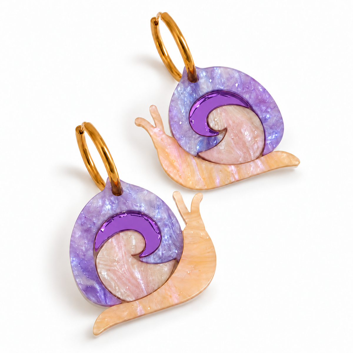 Pendientes Caracoles Mágicos de Sergi Bastian, con metacrilato lila embrujado, cuerpo nacarado albaricoque y espiral de espejo lila intenso.