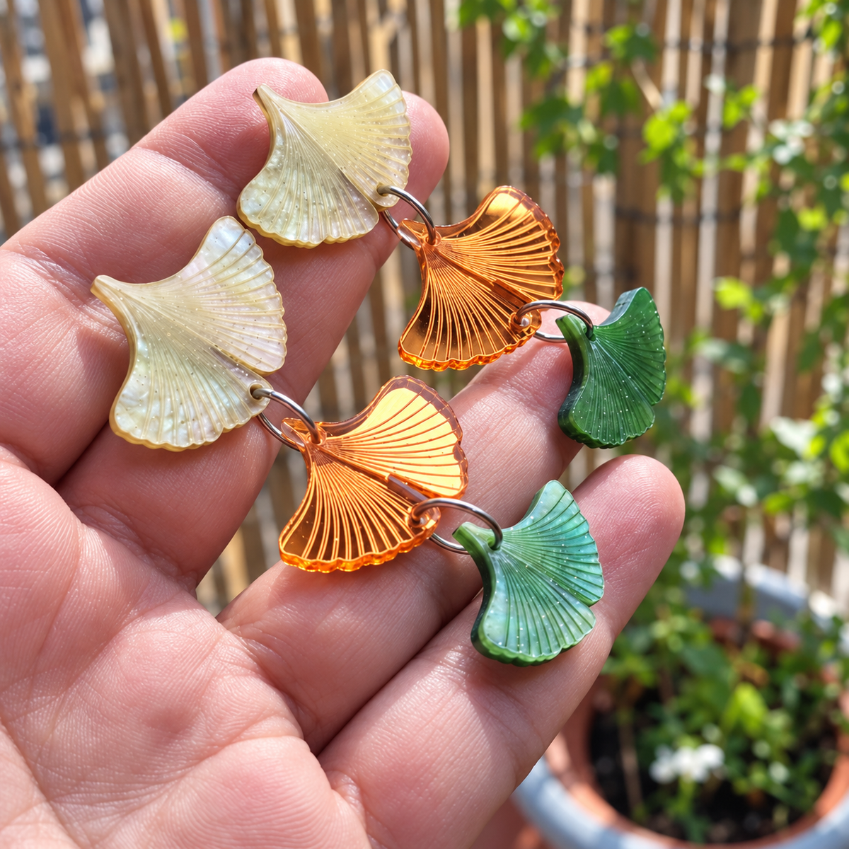 Pendientes Ginkgo de Otoño bajo la luz del sol: reflejos del metacrilato espejo naranja y aguas nacaradas verdes.
