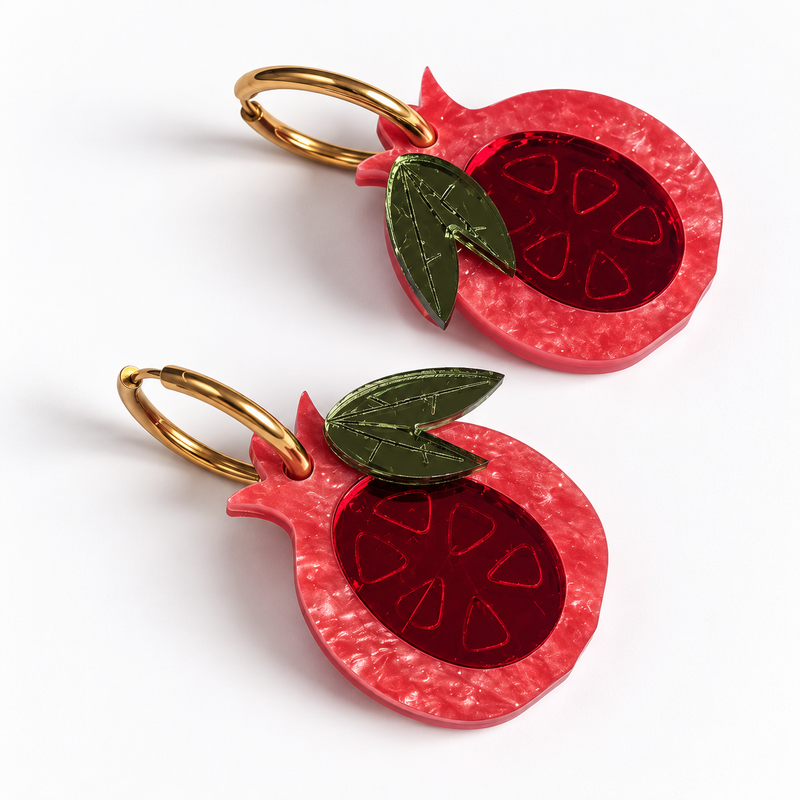 Pendientes Granadas Magic en metacrilato nacarado rosa coral, espejo rojo y hojas en espejo verde oliva, sobre fondo blanco.