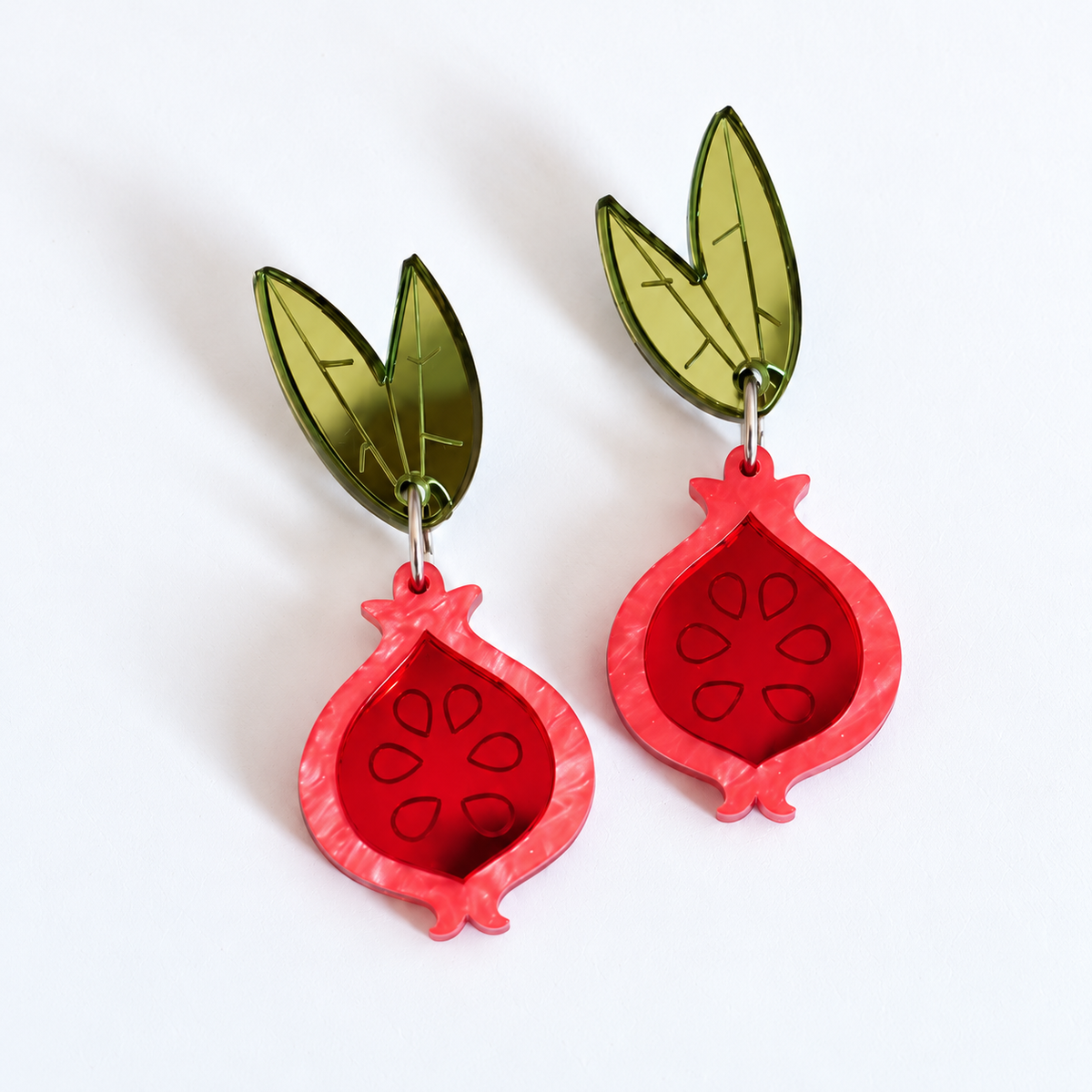Pendientes Granadas Magic de Sergi Bastian en metacrilato espejo rojo y verde oliva, con 6 cm de largo total.