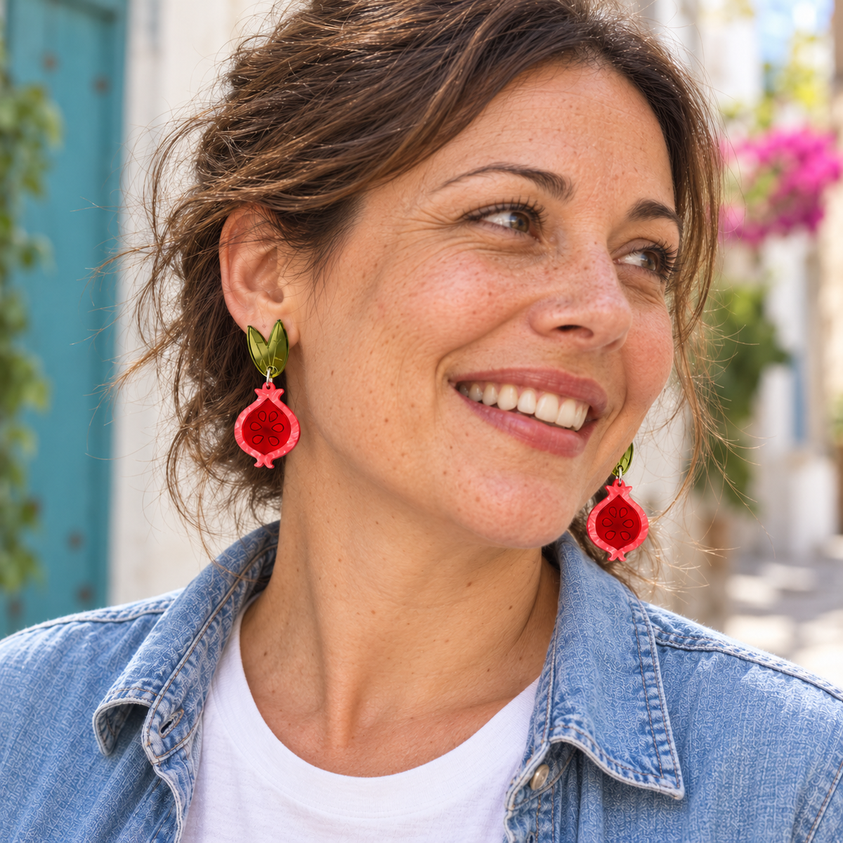 Pendientes Granadas Magic de Sergi Bastian puestos en una mujer sonriente con camisa vaquera; vista orientativa del tamaño.