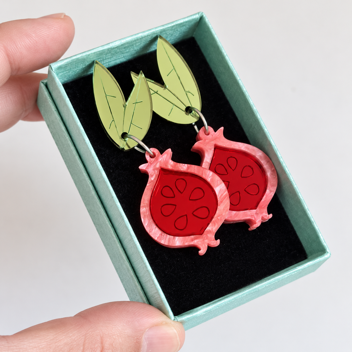 Pendientes Granadas Magic originales con perno de hojas, presentados en caja turquesa.