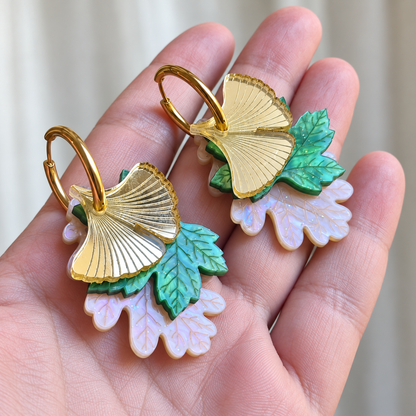 Par de pendientes Luz de Ginkgo sobre una palma para apreciar sus proporciones, el espejo dorado, el verde nacarado y el nácar lila claro.