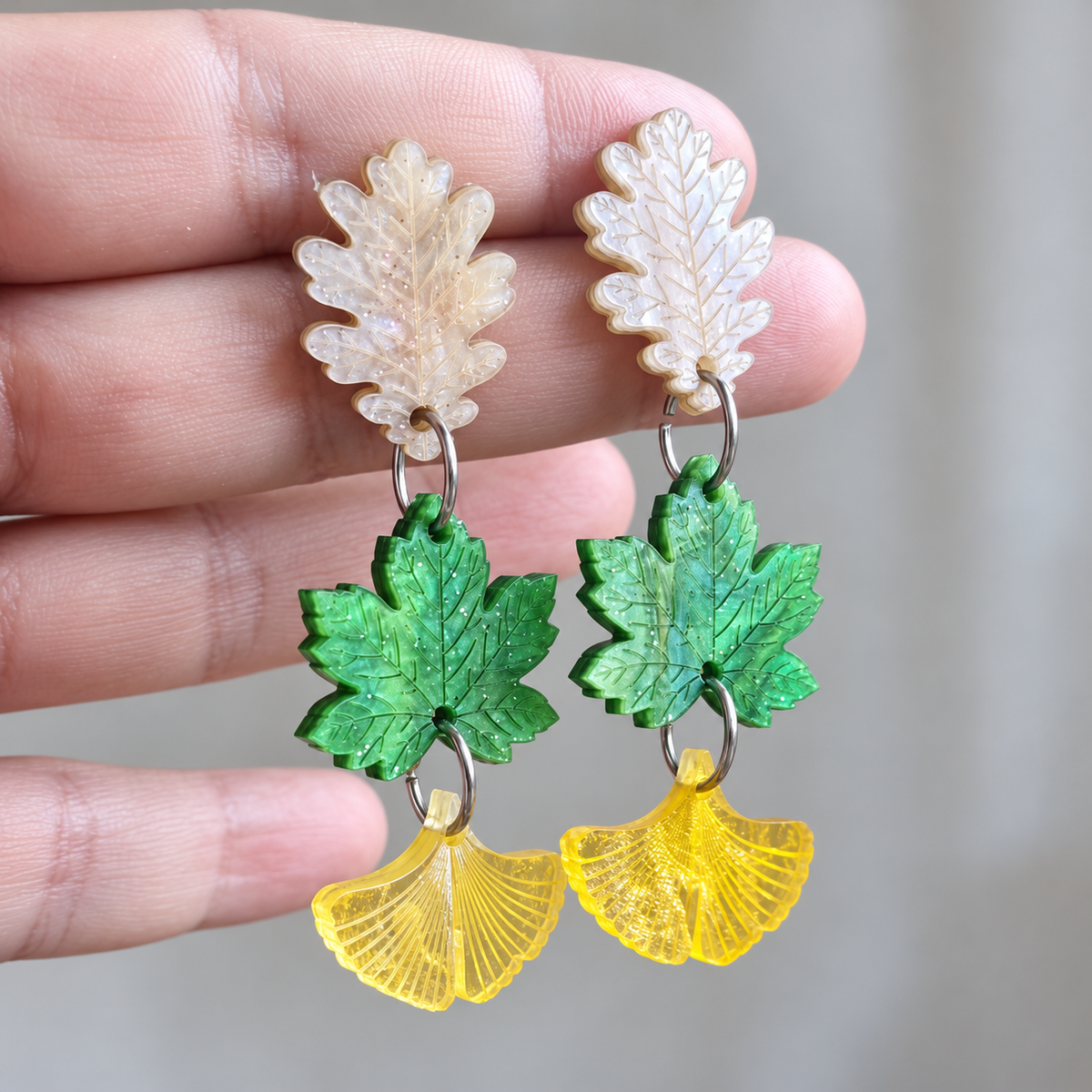 Pendientes Savia del Bosque de Sergi Bastian: hojas en blanco nacarado, verde y amarillo, vista frontal.