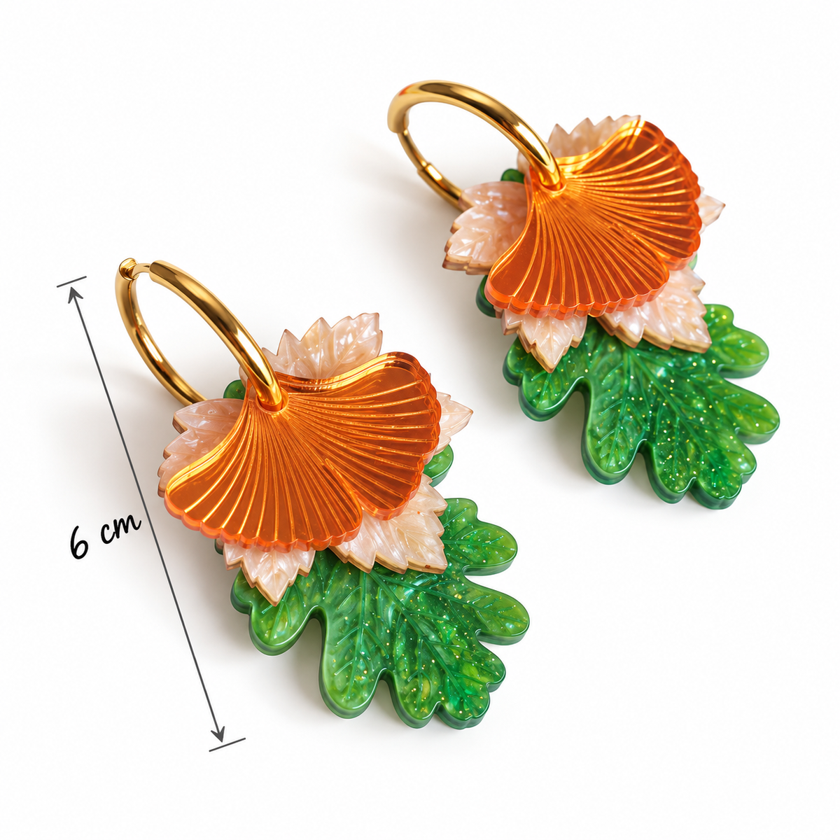 Pendientes Trío del Bosque de Sergi Bastian: tres hojas de metacrilato naranja espejo, nacarado claro y verde, con aro dorado y largo total de 6 cm.
