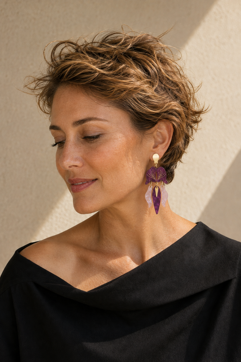 Modelo rubia con pendientes Orquídea lila y rosa en una pose natural; imagen de estilismo generada.